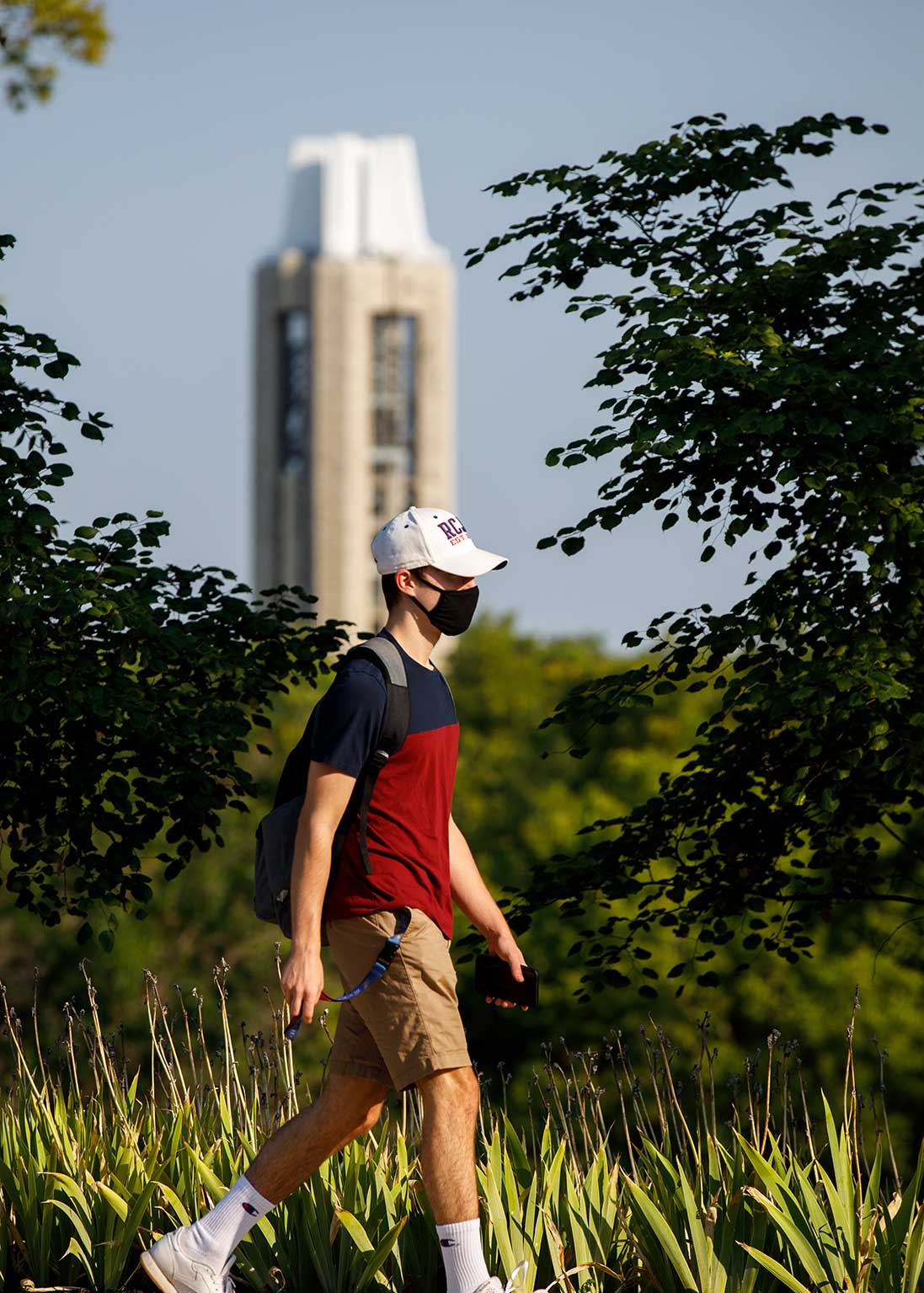 A student walking with the capanele in the background